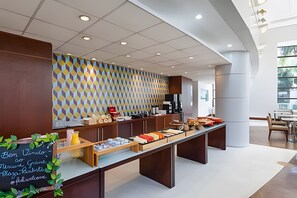 A modern breakfast bar with a geometric patterned wall, a welcome sign, and a variety of food items. - Get a Flat 704 Luxuoso - Av Paulista (São Paulo)