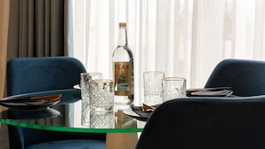 A dining table with a bottle of Peak sparkling water, two glasses, and a plate. - Domus Boutique Hotel (Rabat)