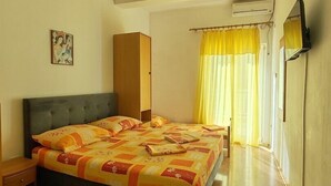 Un dormitorio con dos camas, un armario, un equipo de aire acondicionado y un cuadro en la pared.