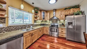 A modern kitchen with wooden cabinets, stainless steel appliances, and a dishwasher.