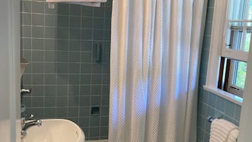 Kombinert dusj/badekar, regndusjhode, håndklær og såpe