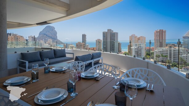 A rooftop dining area with a table set for two, overlooking a cityscape and the sea. - CostaBlancaDreams - Saeta 10B in Calpe (Calpe)