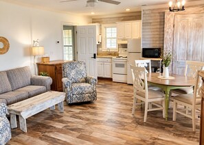 A compact living space with a sofa, armchair, dining table, and kitchenette. - 109 Georges Bay Road(Bermuda Bay) (Surfside Beach)
