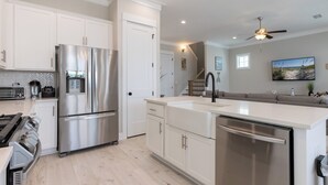 Una cocina moderna con electrodomésticos de acero inoxidable, armarios blancos y una isla grande.