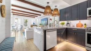 A modern kitchen with dark cabinets, a central island, and pendant lighting.