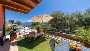 A patio with a table, chairs, and a fruit bowl. - Residence Albatros A1 by Wonderful Italy (Toscolano Maderno)