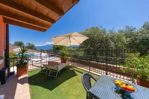A patio with a table, chairs, and a fruit bowl. - Residence Albatros A1 by Wonderful Italy (Toscolano Maderno)