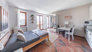 Un dormitorio moderno con cama, escritorio y kitchenette.
