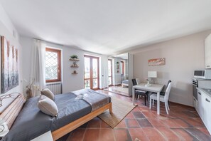 Ein modernes Schlafzimmer mit Bett, Schreibtisch und einer Küchenzeile.
