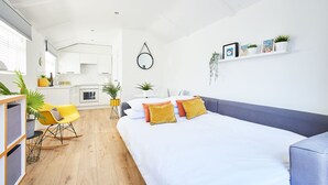 A modern, open-plan living space with a large bed, a dining area, and a kitchen. - Host Stay Sunnyside Studio (Bridlington)