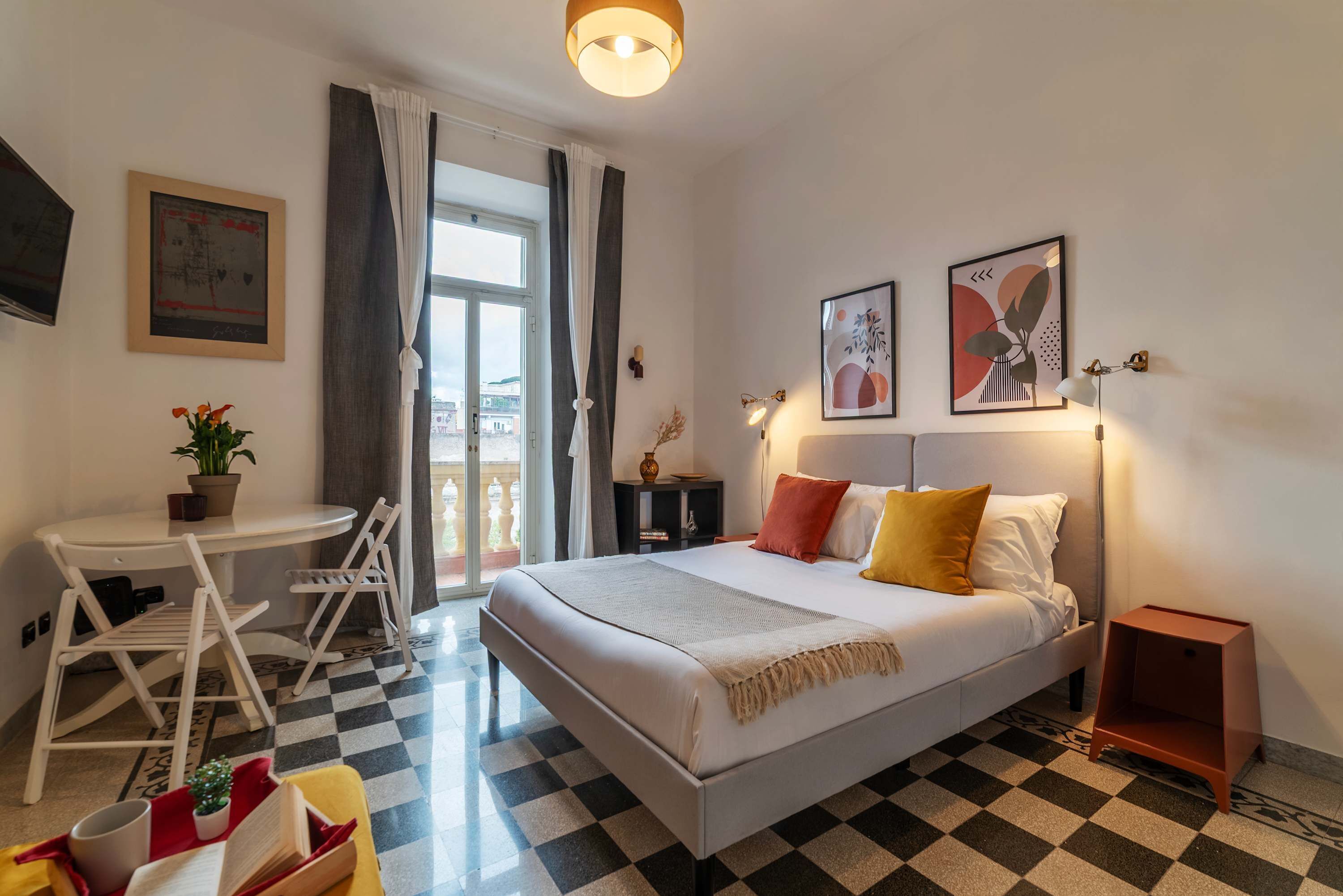 Una habitación de hotel con una cama, un escritorio, una silla y una mesita.