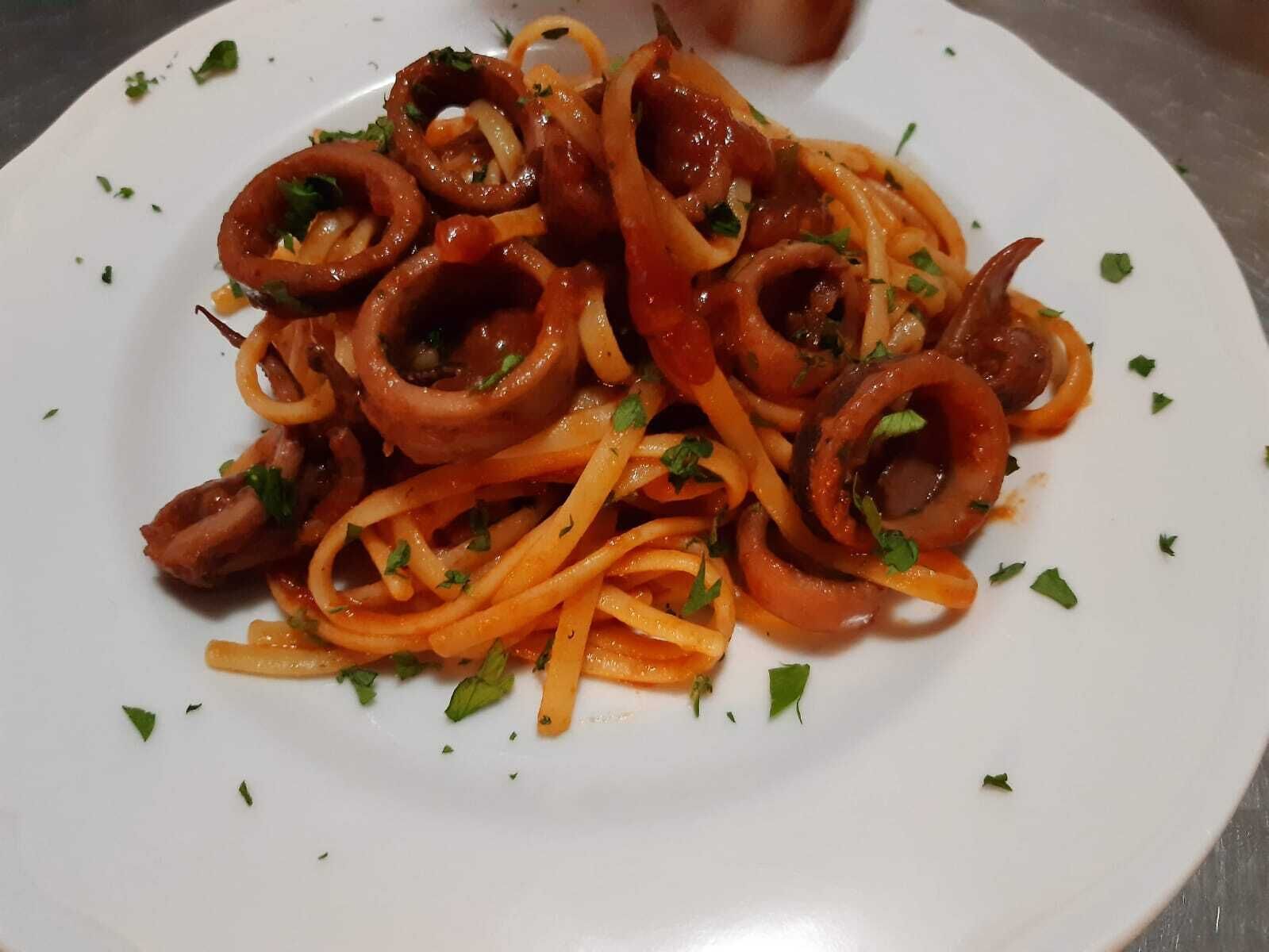 Eine Spaghetti-Platte mit Calamari und gehackten Kräutern.