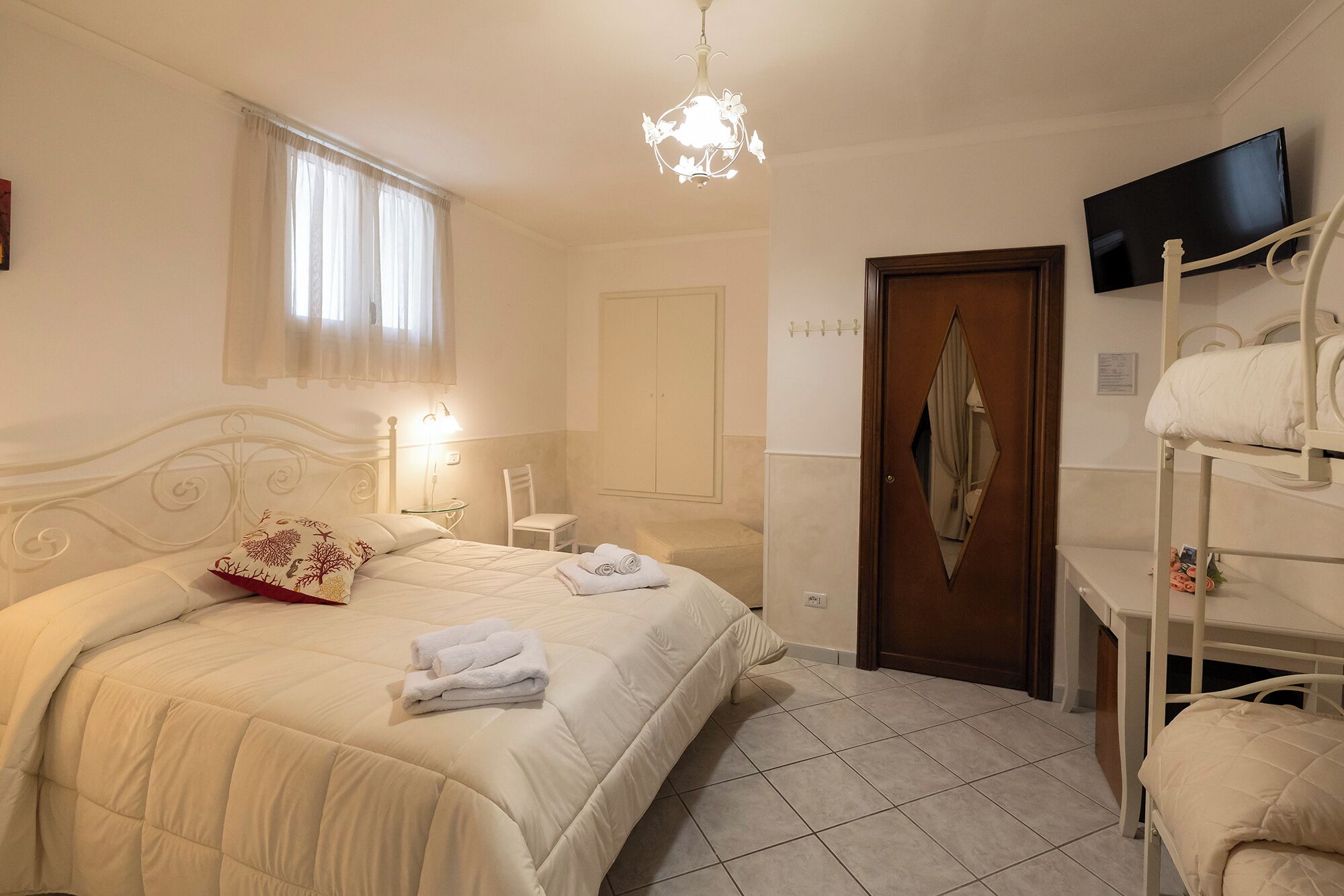 Ein Hotelzimmer mit Bett, Sessel, Fernseher und Kleiderschrank.