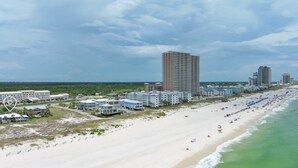 Ein Küstenhotelbereich mit Strandhäusern, einem Sandstrand und Meerblick.