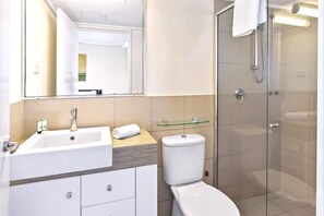 Un bagno moderno con lavandino, WC e cabina doccia in vetro.