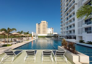 Relax by the rectangular pool with a shallow end and deeper section, surrounded by lounge chairs.
