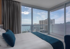 Enjoy a city view from the comfort of a spacious bed against floor-to-ceiling windows.