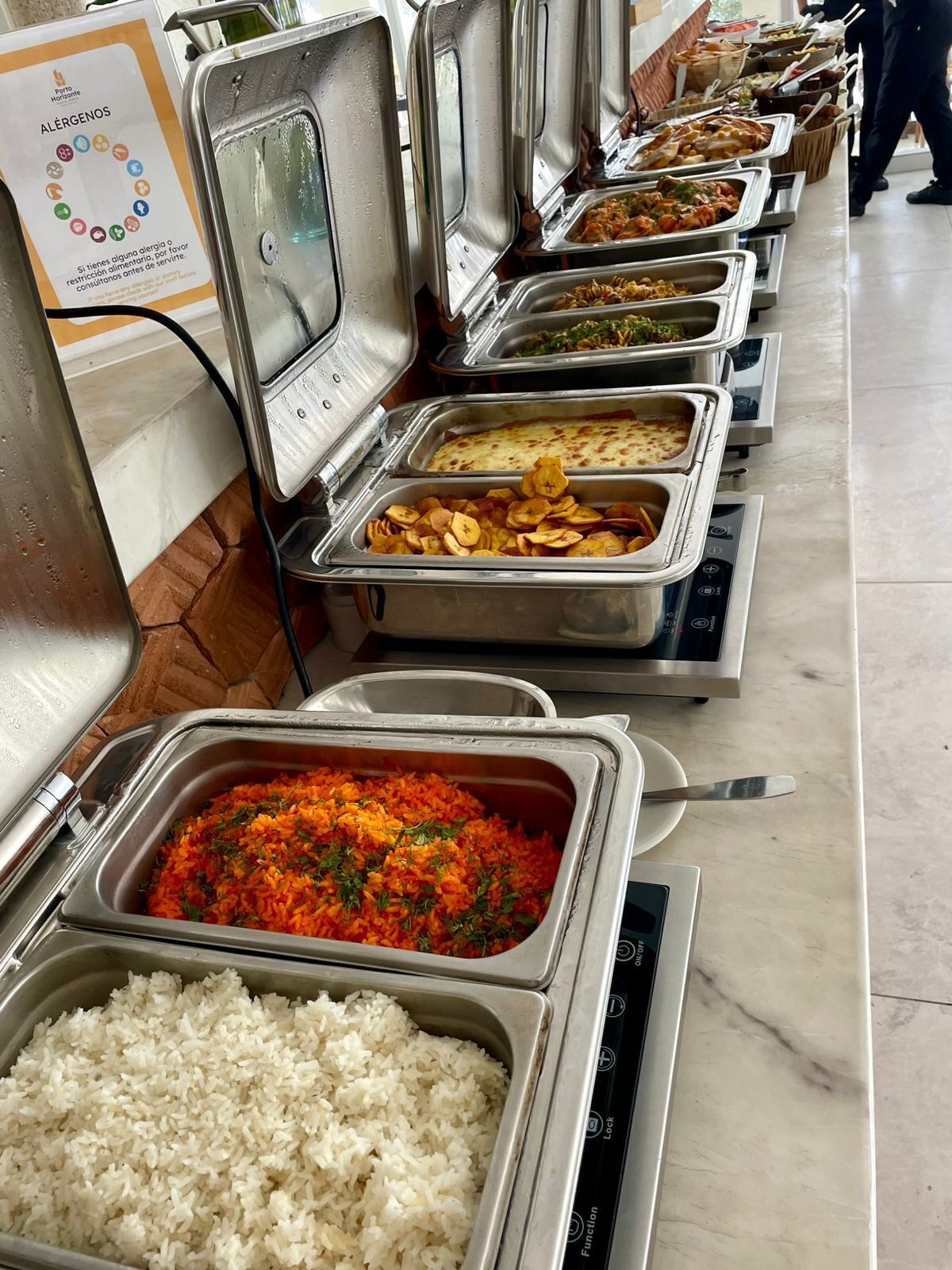 Un buffet con diverse opzioni gastronomiche, tra cui riso, verdure e altri piatti.