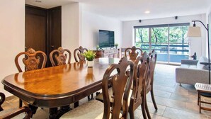 A dining area with a wooden table and chairs, a potted plant, and a TV on the wall. - Bright & Spacious 3-BR-2BTH, near WTC/ Insurgentes (Ciudad de México)