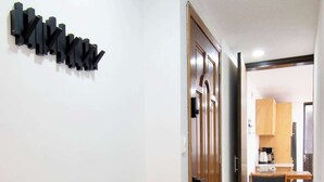 A hallway with a wooden door, a kitchen area with a dining table and chairs, and a stone-tiled floor. - Bright & Spacious 3-BR-2BTH, near WTC/ Insurgentes (Ciudad de México)