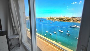 Ein Balkon mit Blick auf einen Jachthafen und die Stadtlandschaft.