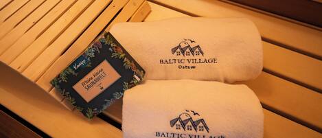 A wooden bench with two towels and a box.