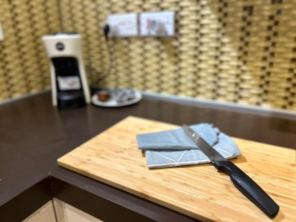 A kitchen counter with a cutting board, a knife, and a coffee maker. - TOP BBQ+FUN St. Julians Apartment 7 (St Julians)
