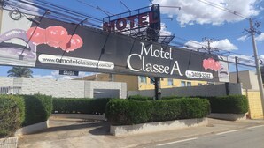 A large billboard advertising Motel Classe A with a website URL and a phone number. - Motel Classe A  (Limeira)