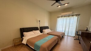 Hotelkamer met twee bedden, een bureau, een stoel, een plafondventilator en een airconditioner.