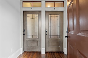 Two doors labeled A and B, each with a frosted glass panel and a modern doorbell.