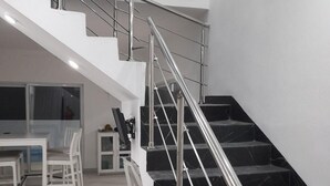 A modern interior with a staircase, white furniture, and a painting on the wall. - Tropical Villa Escape in Sosua (Sosúa)