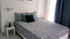 A bedroom with a bed, a nightstand, a ceiling fan, and two framed pictures on the wall. - Sosua Villa Retreat - Calle Pedro Clisante (Sosúa)