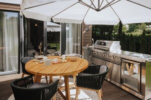 Una mesa de madera con cuatro sillas, una parrilla y un horno de vidrio.