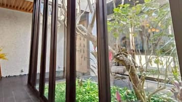 Una habitación con vistas a un jardín a través de amplios ventanales.
