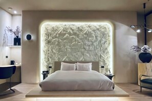 A modern bedroom with a unique textured headboard, a large bed, bedside tables, and a minimalist decor.