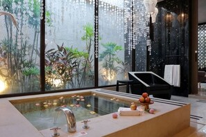 A modern spa area with a large glass-enclosed hot tub, a black lounge chair, and a view of indoor plants. - Mulan Boutique Hotel - Taipei Dazhi Branch (Taipei)