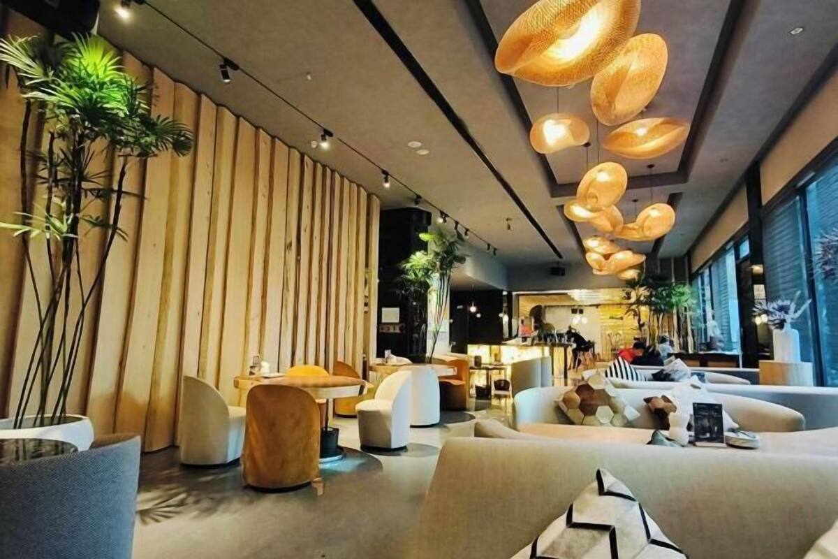 A modern interior with wooden slats, round seating, and hanging pendant lights.