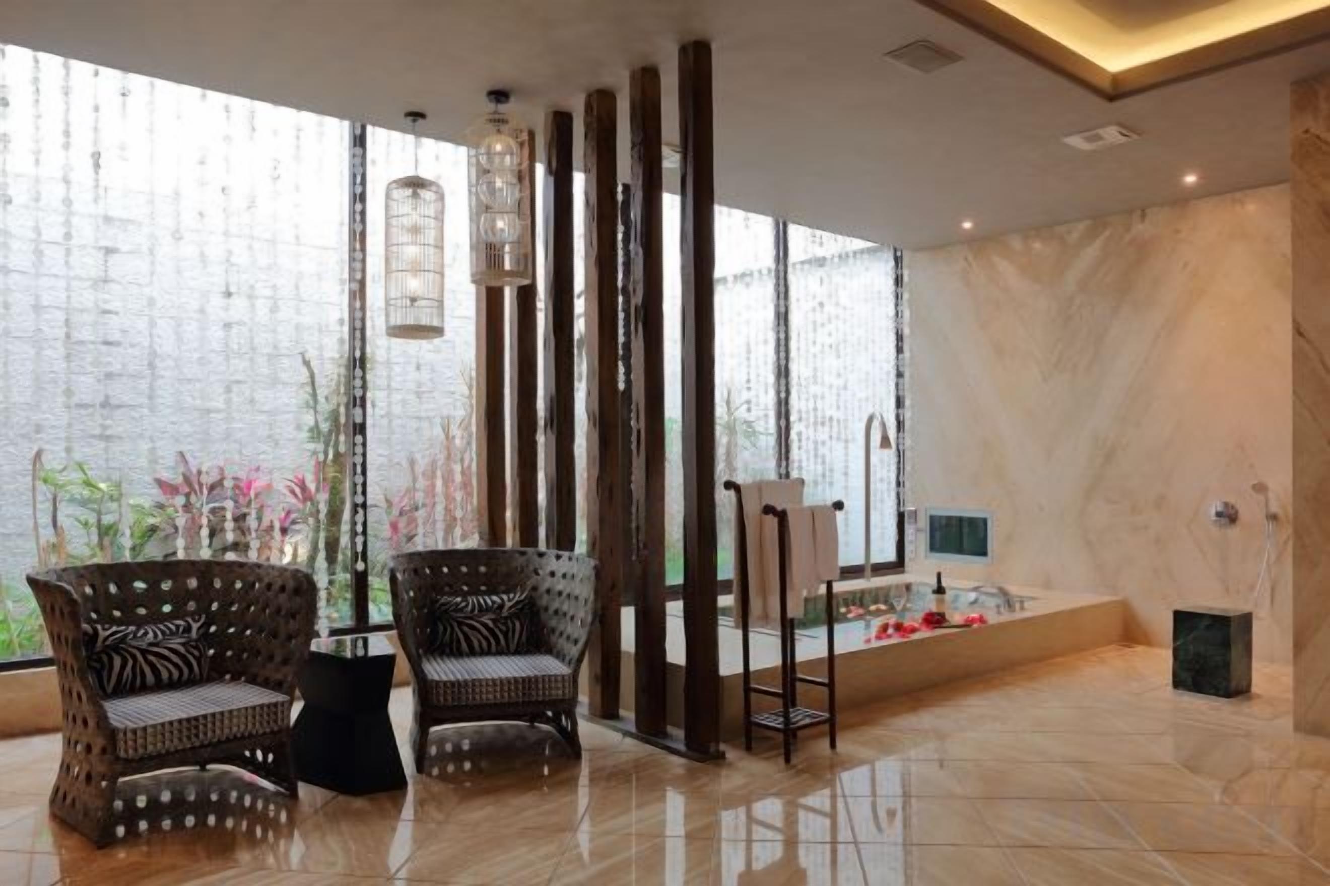 A modern interior with two wicker chairs, a tall column, and a tiled floor.