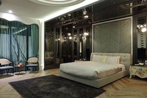 A bedroom with a large bed, a dark-colored wardrobe, a small table with a lamp, and a chair. - Mulan Boutique Hotel - Taipei Dazhi Branch (Taipei)