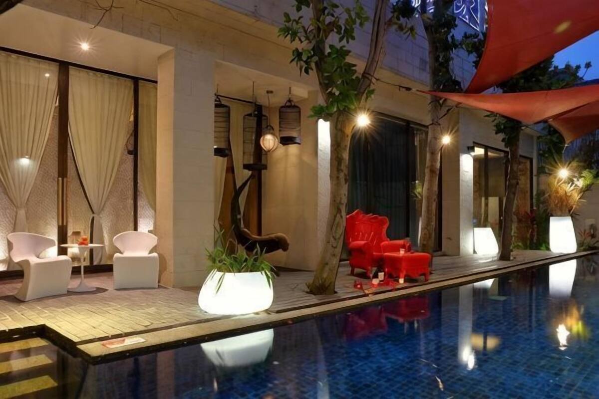 A poolside area with lounge chairs, a small table, and a potted plant.