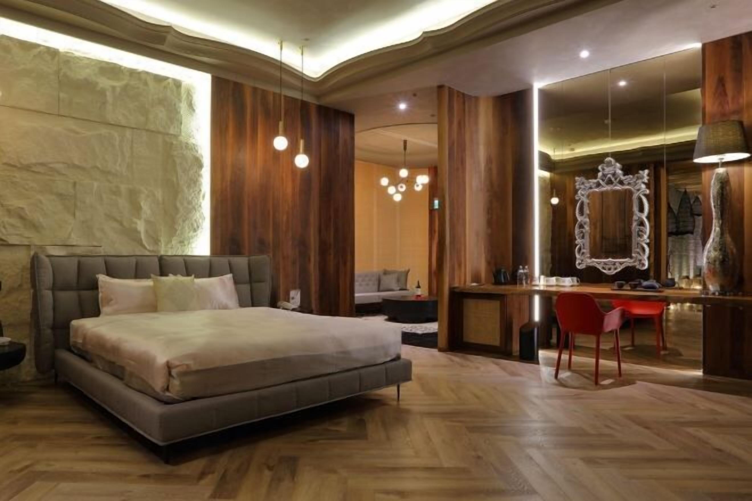 Un dormitorio moderno con una cama grande, un escritorio y un espejo.