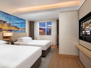 A hotel room with three beds, a large window with curtains, a flat-screen TV, and a painting on the wall. - Vienna International Hotel (Changsha)
