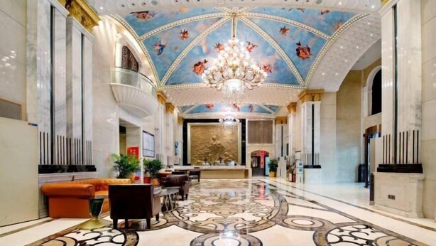 A grand lobby with a high ceiling, ornate chandelier, and a patterned floor. - Vienna International Hotel (Changsha)