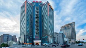 A tall, modern building with a prominent entrance and multiple floors. - Vienna International Hotel (Changsha)