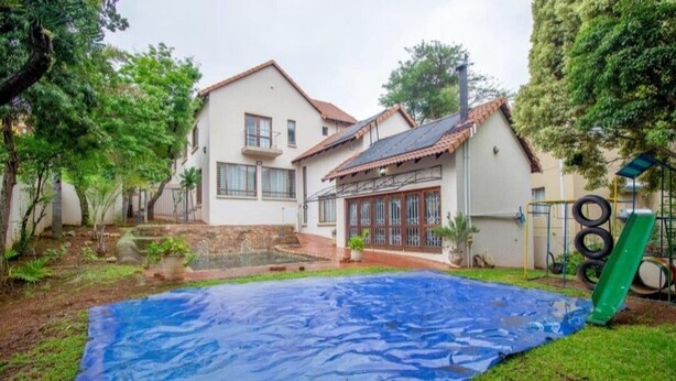 Il s’agit d’une propriété résidentielle dotée d’une piscine couverte, d’un jardin clôturé et d’une maison avec un toit en tuiles.