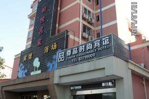 Un letrero de hotel con el nombre 'ZUNPIN FASHIONABLE HOTEL' y un número de contacto.