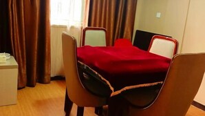 Una habitación pequeña con una cama individual, una mesita de noche y una ventana con cortinas.
