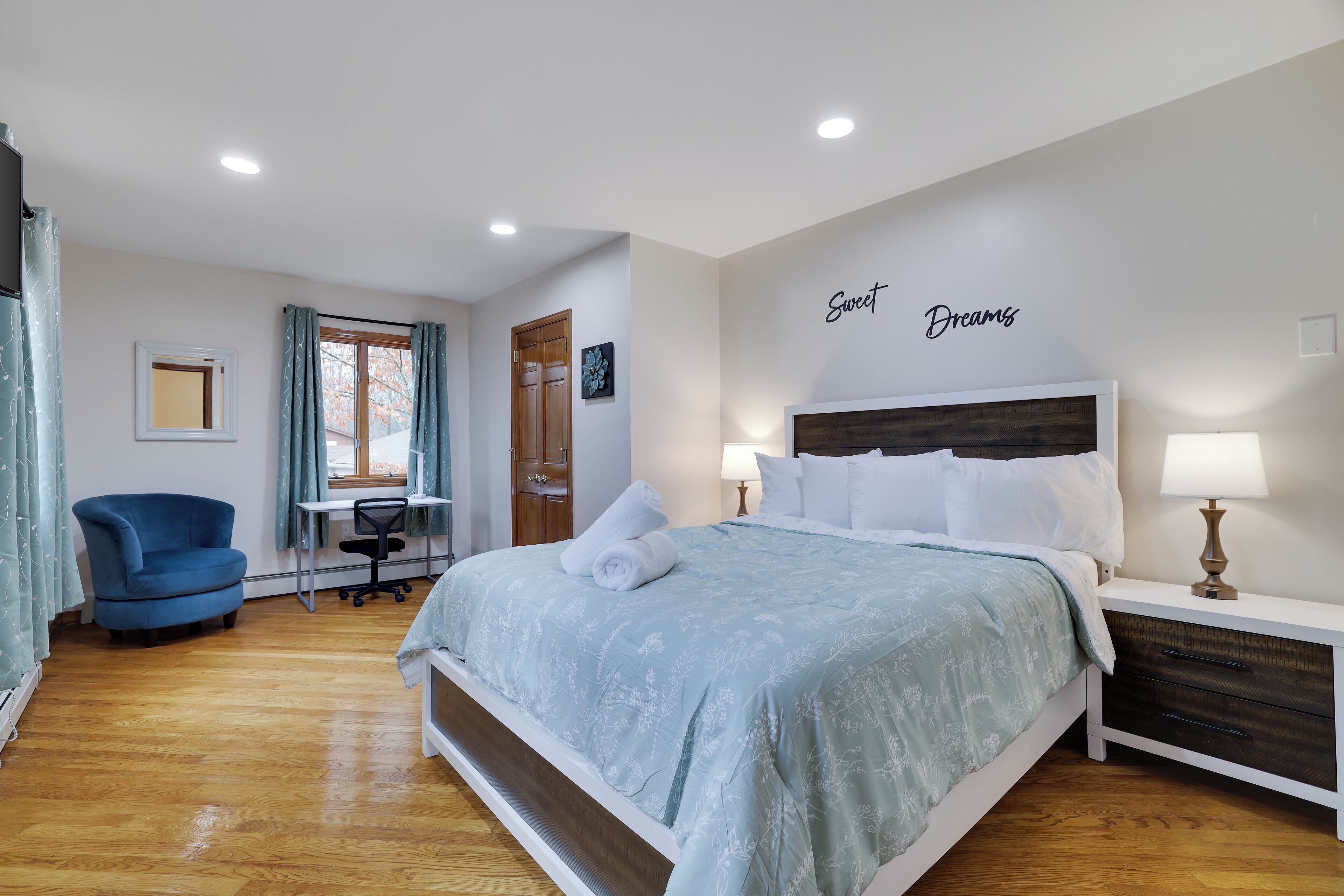 Ein Schlafzimmer mit Bett, Schreibtisch, Stuhl und Nachttisch.