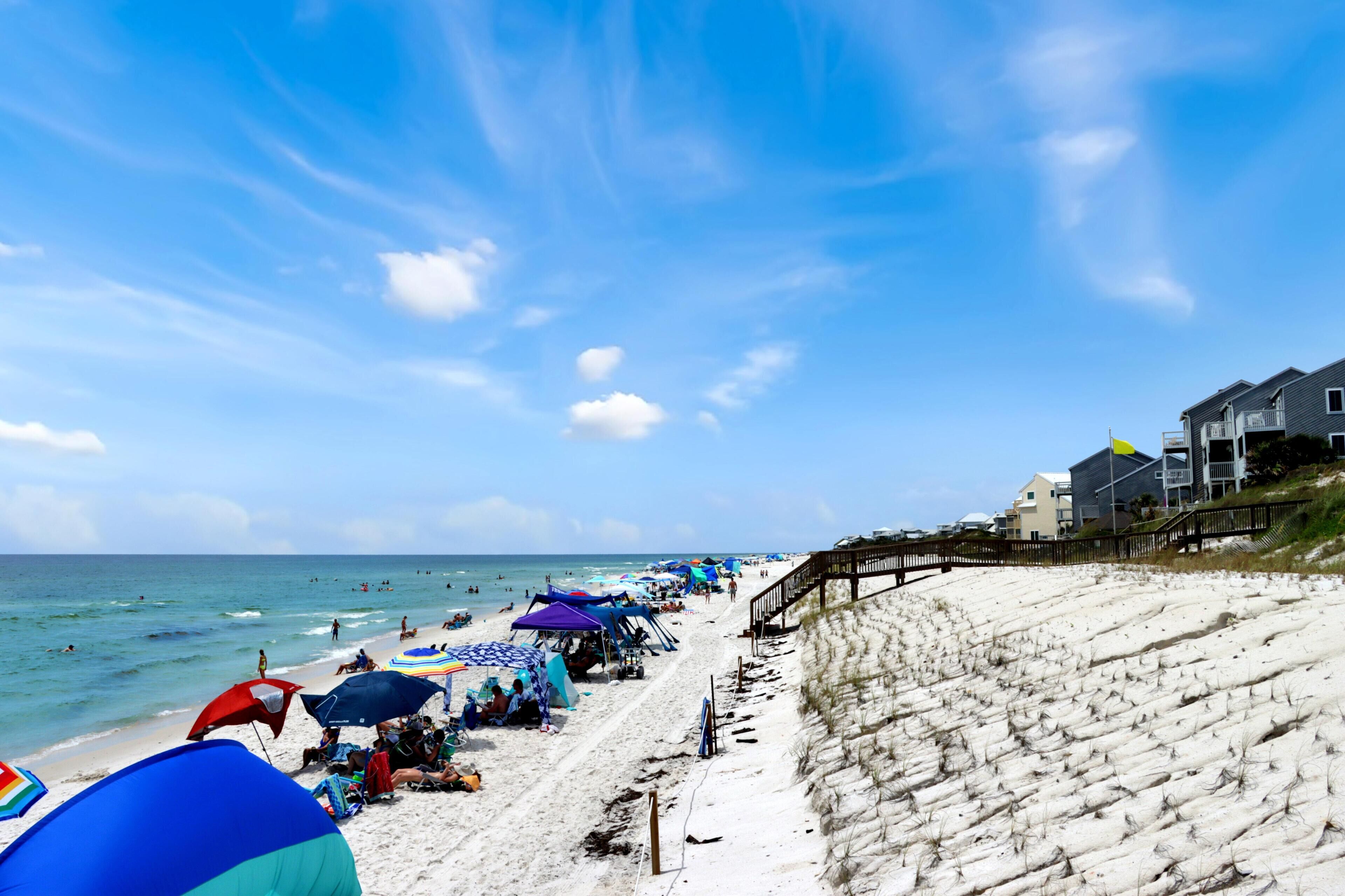A beach with umbrellas and people.