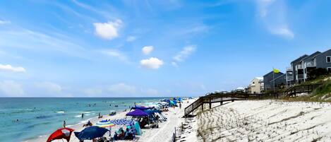 A beach with umbrellas and people.